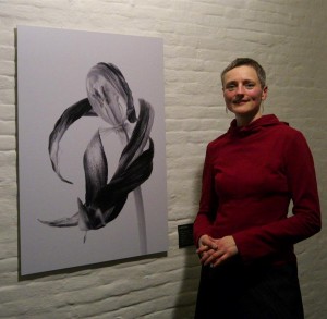 Die Künstlerin Martina Detjen steht am Freitag bei der Vernissage ihrer Ausstellung "Wandlungen. Der andere Blick" neben einem ihrer Bilder mit dem Titel "Umarmung".
