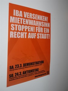 Ein Plakat weist auf die Demonstrationen am Eröffnungswochenende der IBA hin.
